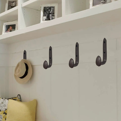 Four Pack Badass Cast Iron Wall Hooks In Rustic Black Vintage Coat Rack on wall holding a hat, heavy duty entryway storage organizer.
