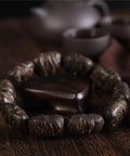 Dope Agarwood Sinensis Jewelry Unisex Adjustable Bracelet with natural burl patterns on wooden beads, dense black oil finish.