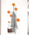 Hella Sturdy Wall Mount Coat Rack With Creative Cloak Hooks For Entryway Organization Decorative Hanging Clothes Towel Storage Easy Install Space Saving Home Essential with orange hooks and a striped coat.