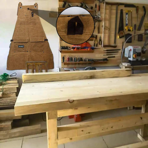 Heavy Duty Waxed Canvas Apron For Woodworking With Pockets And Cross Back Straps displayed in workshop with tools on wall
