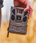 Hella Rugged Cellular LTE Trail Camera With Kick Ass Night Vision And Waterproof Build designed for wildlife tracking held in hand.