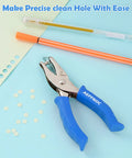 One Hole Paper Punch With Soft Grip Handle One Quarter Inch Hole Puncher For Crafts And Scrapbooks With Mess Tray Six Sheets Capacity Durable Metal Construction Blue shown with punched paper and pens.