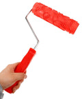 Professional Grade Slick Wood Grain Texture Paint Roller for Interior Wall Decoration held in hand, red rubber grip, embossed pattern.