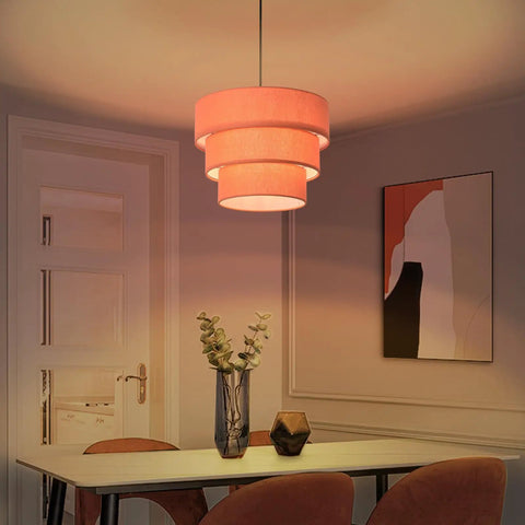 Orange Plug In Pendant Light With Three Tier Mid Century Modern Linen Shades Stylish Hanging Chandelier illuminating a dining area.