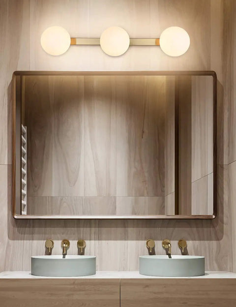 Slick Modern Brass Gold Three Light Vanity Fixture With Milky Glass Shades for bathroom over mirror wall sconce.