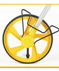 Close-up of Hella Reliable Digital Measuring Wheel With Crisp Backlit Display for smooth distance marking, featuring a sturdy yellow wheel.