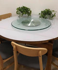 Smooth Operator Tempered Glass Lazy Susan Turntable on round table with wooden chairs and plants, perfect for backyard BBQs.