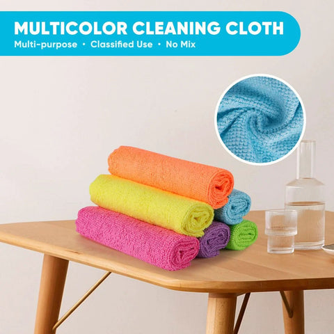 Six colorful microfiber cleaning cloths rolled on a wooden table (orange, yellow, pink, purple, blue, green).