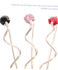 Stylish hair clip featuring black, pink, and red stones on a wavy gold base, perfect for enhancing hairstyles.