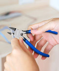 Person using 10 Pack 6 Inch Wire Cutters For Crafting And DIY Projects, blue handle, cutting ribbon with spring-loaded pliers.