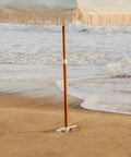Heavy Duty Beach Umbrella Anchor With Spiral Screw Base Universal Size Fits Most Umbrellas Perfect For Sand Or Grass Keeps Your Beach Shade Steady In Windy Conditions White, shown securing umbrella in sand at the beach.