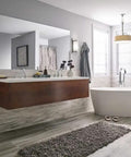 Modern bathroom with freestanding tub, wall-mounted vanity, and brushed nickel pendant lighting.