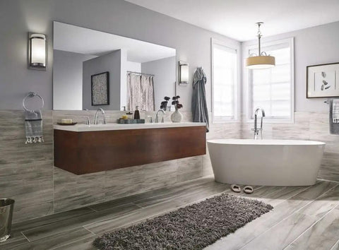 Modern bathroom with freestanding tub, wall-mounted vanity, and brushed nickel pendant lighting.