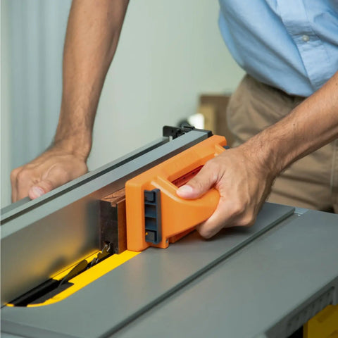Person using Grab Push Block With Retractable Holder And Offset Handle for easy material control on a table saw.