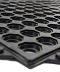 Close-up of an interlocking rubber floor mat with drainage holes, non-slip surface for indoor and outdoor use, 36 inch square tile.