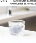 Glass of water with Water Filter Refills For 2.0 K-Cup Pod Coffee Makers, 6 Count Replacement Cartridges beside a sink.
