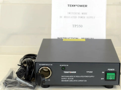 TP350 23 Amp DC 13.8V Switching Power Supply With Cigarette Plug For Ham Radio And CB Radios on a table with manual and cords.