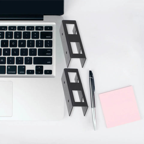 Slick Black Desk Laptop Rack And Tablet Storage Holder, compact metal design next to laptop and stationery.