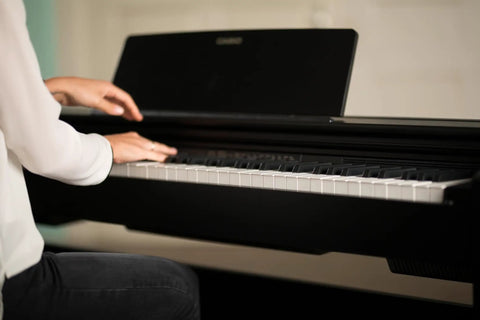 Person playing the Privia PX 870 88 Key Weighted Console Digital Piano With Tri Sensor II Scaled Hammer Action For Real Feel.