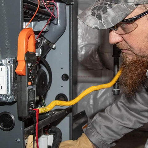 Technician using Magnetic Hanger for Clamp Meters and Multimeters with Powerful Rare Earth Magnets in a field service setting.