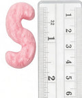 Close-up of pink Boss Level Anti Static Packing Peanut next to a ruler showcasing size for shipping and moving purposes.