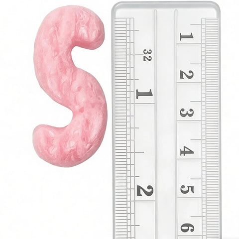 Close-up of pink Boss Level Anti Static Packing Peanut next to a ruler showcasing size for shipping and moving purposes.