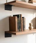 16 Piece Rock Solid L Bracket Set 2 By 2 By 4 Inch 14 Gauge Steel Corner Brackets supporting a wooden shelf with books.