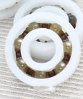 Premium Pom Plastic Ball Bearings 5 Piece Kit showing white polymer with brown balls for smooth rotation in use.