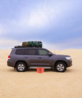 BotaBay 4 Ton Off-Road Air Jack With 8800 Lbs Capacity Inflatable Soft Jack for Truck and SUV on sandy terrain next to a grey vehicle.