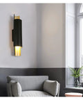 Sleek Black Wall Lamp With E27 Socket For Living Room TV Wall And Entryway Glare Free Indoor Sconce mounted beside a grey armchair.