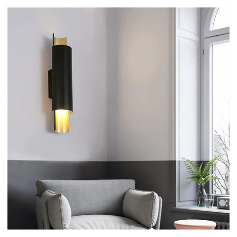 Sleek Black Wall Lamp With E27 Socket For Living Room TV Wall And Entryway Glare Free Indoor Sconce mounted beside a grey armchair.