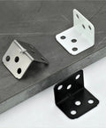 Rock Solid Heavy Duty L Brackets No Sweat Assembly Furniture Hardware Pack with black, white, and silver metal L shaped corner supports.