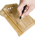 Top Tier 1/12 Scale Dollhouse Accessories Kit With Legit 700 Pieces Of Mini Knobs Hinges Handles And Locks Plus Screws And Screwdriver showing a hand installing a hinge on a wooden dollhouse door.