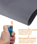 Hand holding a lighter near the gray Anti Static Foldable Non Slip Premium Flexible Silicone Soldering Mat 15 Point 8 By 11 Point 8 Inches.