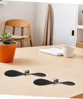 Two black 5.70-In fold-resistant model airplane propellers on a table, part of the 10 sets for STEM DIY projects, RC accessories