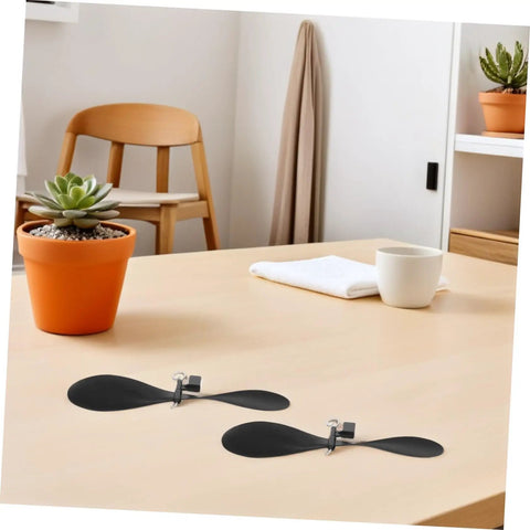 Two black 5.70-In fold-resistant model airplane propellers on a table, part of the 10 sets for STEM DIY projects, RC accessories