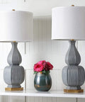 Cleo Modern Grey Textured Ceramic Table Lamps 32-Inch Set Of 2 With LED Bulbs Included Off White Cotton Shade displayed on shelf