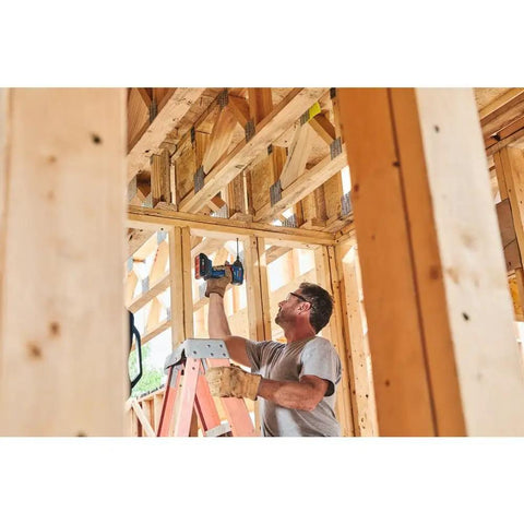 Worker using 18V Brushless Connected-Ready 1/4 In Hex Impact Driver Bare Tool With Auto Bolt Release on wood frame construction