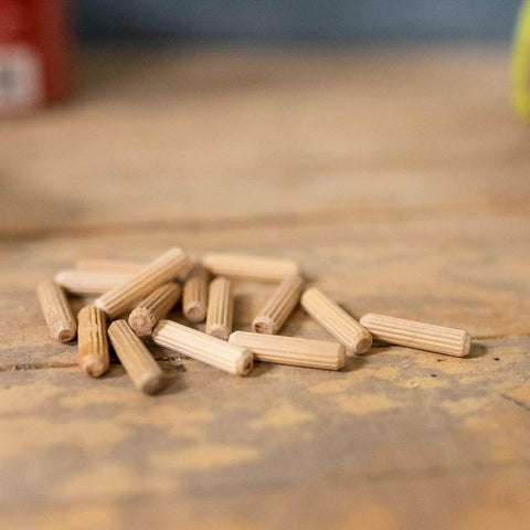 1/4-Inch Fluted Wood Dowel Pins, 72 Count Pack, Straight-Grain Hardwood Dowels For Rock-Solid Joints, Chamfered Ends For Easy Insertion, Expands With Water-Based Glue For Tight Bond, FSC Ethically Sourced scattered on a wood surface.