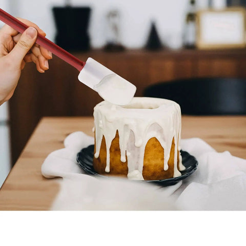 Using 3 Pack Heat Resistant Silicone Spatulas 9.5 Inch Nonstick Safe BPA Free Pro Grade to frost a cake with icing.