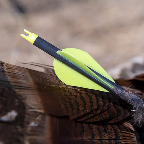 Yellow vane on an arrow, background of feathers, different item than 2-Inch Shield Vanes In Pink, Pack Of 36 For Target And Field Archery