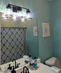 Black 3 Light Industrial Vanity Sconces With Hammered Glass Shades above bathroom mirror, vintage rustic farmhouse style.