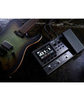 GX-10 Compact Guitar And Bass Effects Processor With GX-100 Sound Engine, shown with guitar on dark surface