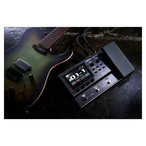 GX-10 Compact Guitar And Bass Effects Processor With GX-100 Sound Engine, shown with guitar on dark surface