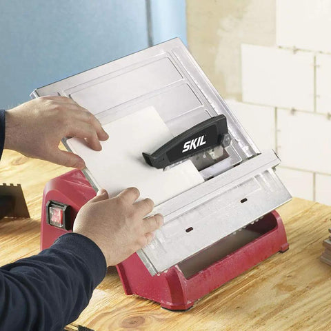 Heavy Hitter 7 Inch Wet Tile Saw With Rust Proof Stainless Top And Adjustable Rip Fence cutting ceramic tile set on flat surface.