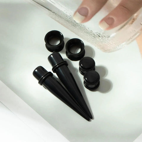 Starter Pack For Ear Stretching 50 Piece Kit With 14G To 00G Acrylic Tapers And Plugs Silicone Tunnels close-up on black pieces