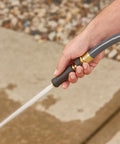 Hand holding Solid Brass Twist Nozzle For Garden Hose With Adjustable Spray Pattern From Jet To Gentle Rinse Full Flow Tip.