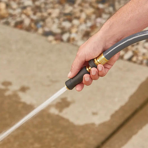 Hand holding Solid Brass Twist Nozzle For Garden Hose With Adjustable Spray Pattern From Jet To Gentle Rinse Full Flow Tip.