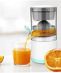 Premium Portable Electric Citrus Juicer with glass full of orange juice and juicer pouring juice from fresh orange.