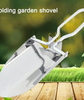 Compact Folding Camping Shovel With Durable Stainless Steel Build For Outdoor Survival Mini Shovel For Hiking And Trowel Versatile Entrenching Tool With Ergonomic Handle And Carrying Pouch In Silver displayed on grass
